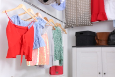 Blurred view of dressing room with different clothes and accessories