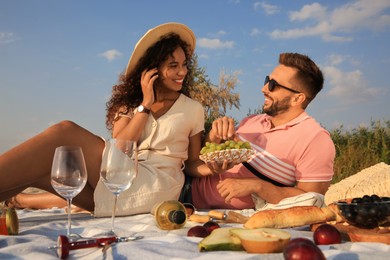 Photo of Lovely couple having picnic outdoors on sunny day