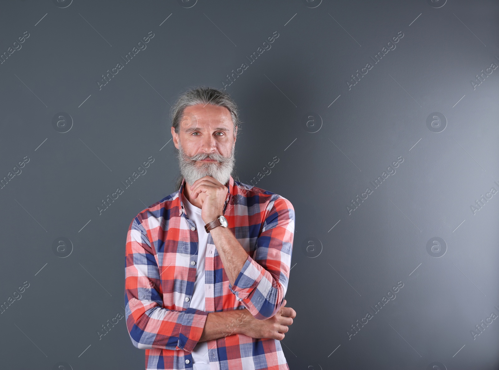 Photo of Handsome bearded mature man on color background