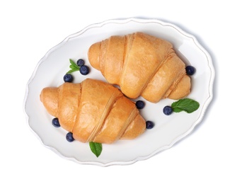 Plate with tasty croissants and berries on white background, top view