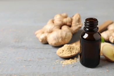 Ginger essential oil in bottle on light grey table. Space for text