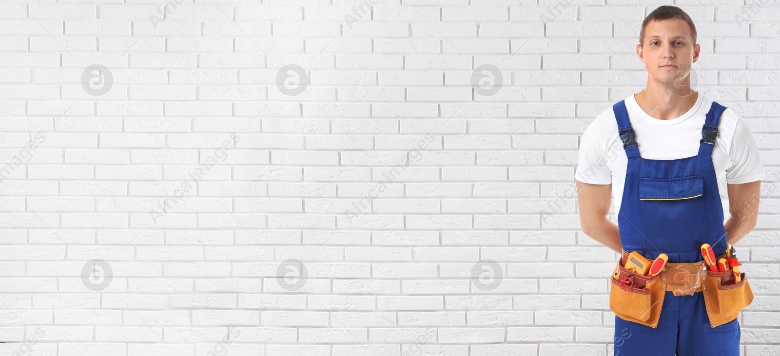 Image of Electrician with tools near white brick wall, space for text. Banner design