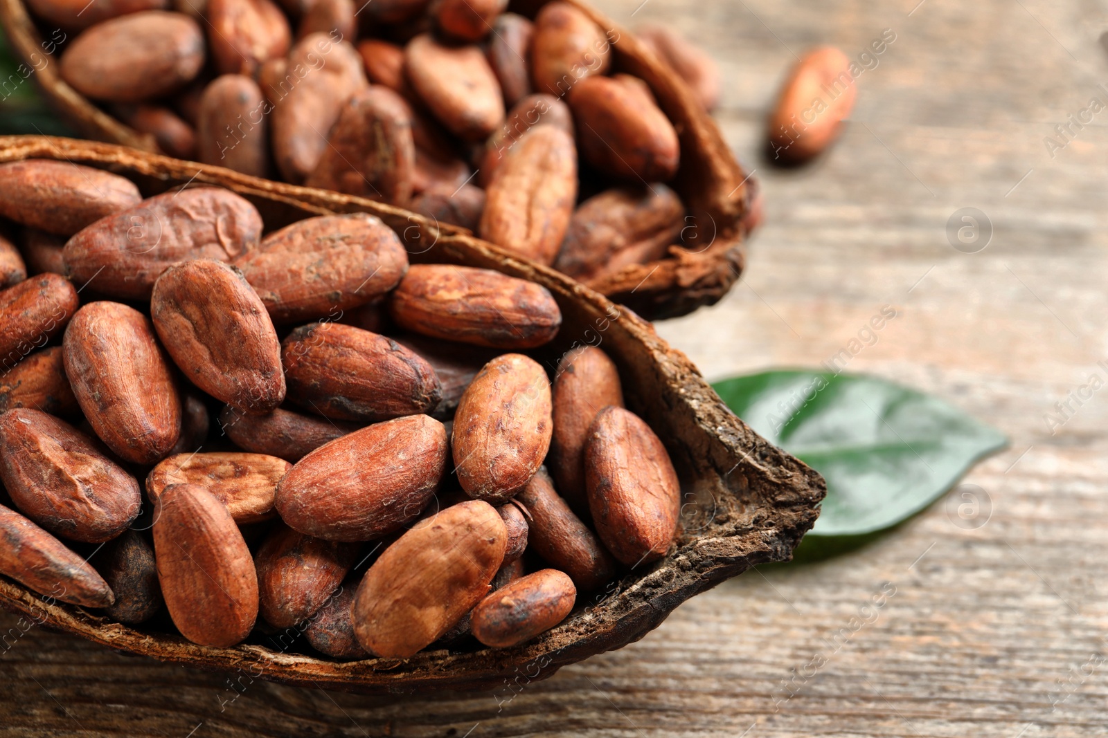 Photo of Cocoa pods and beans on wooden table, closeup