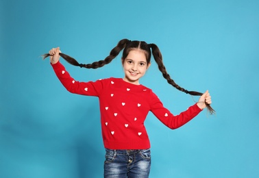 Portrait of little girl posing on color background