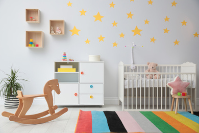 Photo of Stylish baby room interior with crib and toys