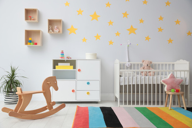 Stylish baby room interior with crib and toys