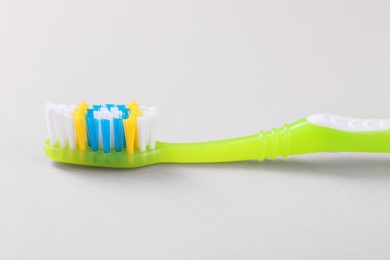 One plastic toothbrush on light background, closeup