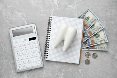 Photo of Flat lay composition with ceramic model of tooth and money on grey table. Expensive treatment