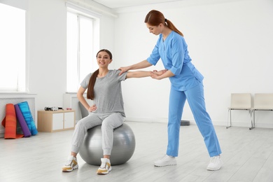 Photo of Professional physiotherapist working with female patient in rehabilitation center