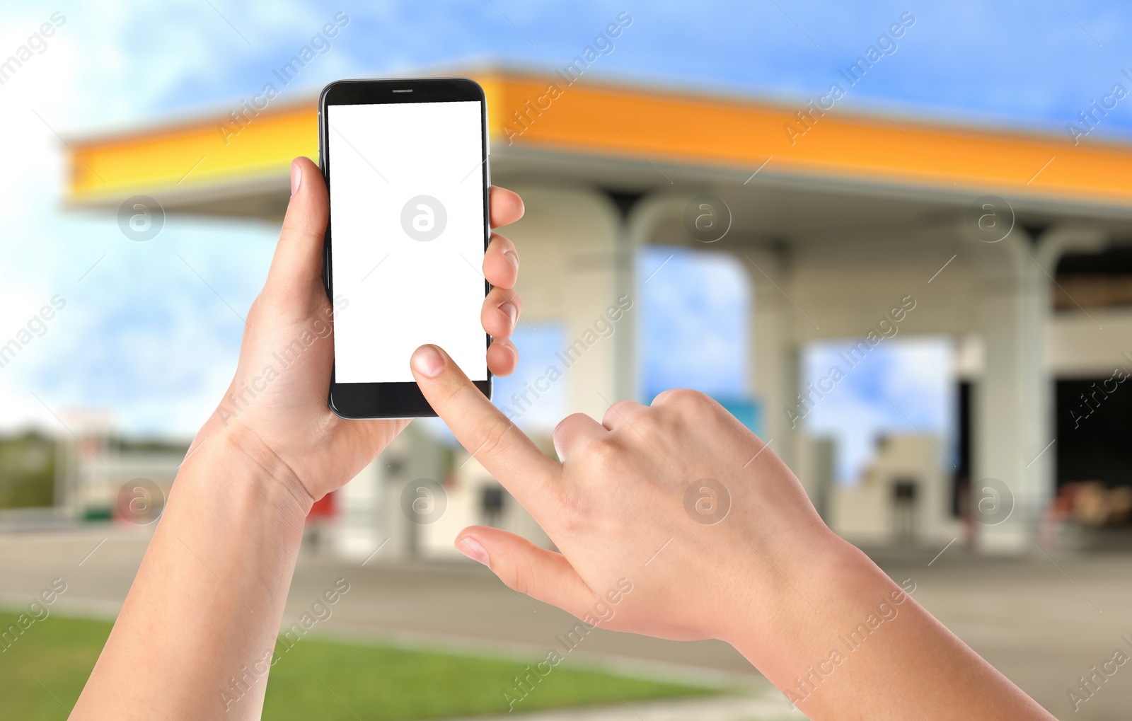 Image of Man paying for refueling via smartphone at gas station, closeup. Device with empty screen