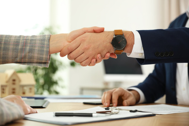 Photo of Real estate agent shaking hands with client in office, closeup