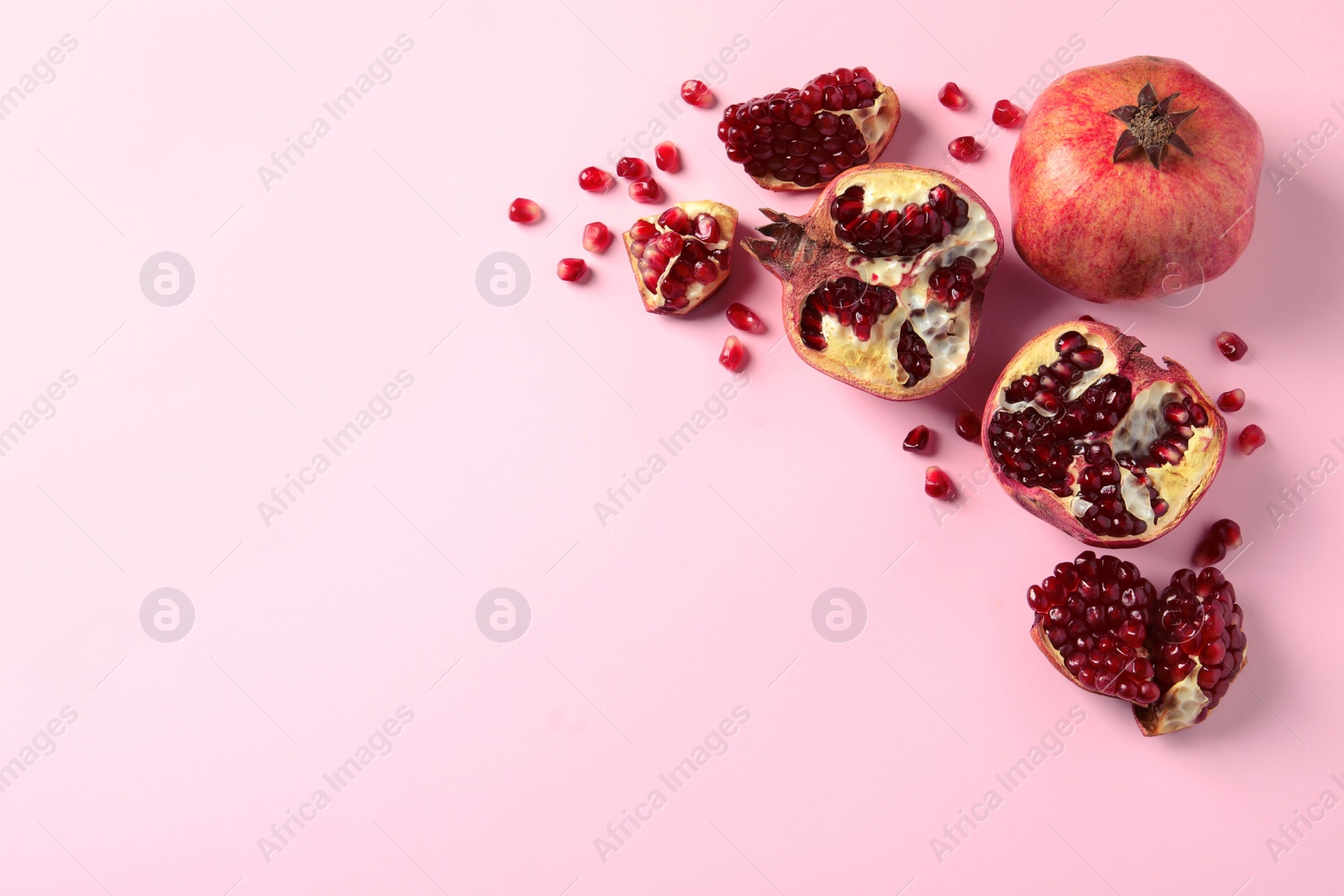 Photo of Composition with ripe pomegranates and space for text on color background, top view