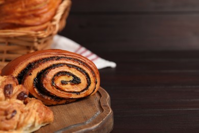 Photo of Different tasty freshly baked pastries on wooden table, closeup. Space for text