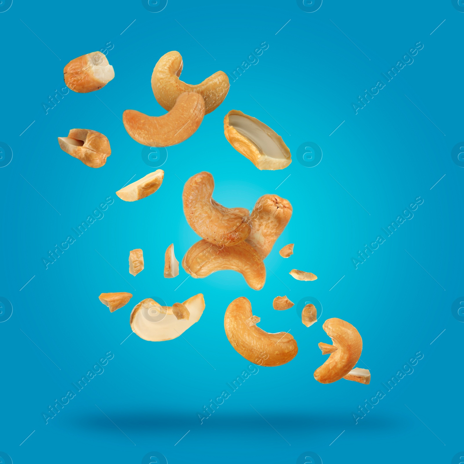 Image of Tasty cashew nuts flying on turquoise background