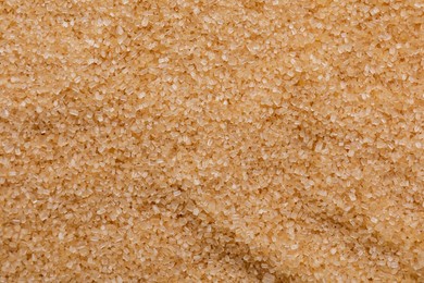 Brown granulated sugar as background, top view