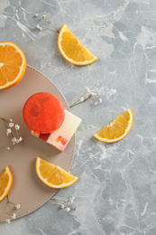 Flat lay composition with soap and orange slices on light grey marble background