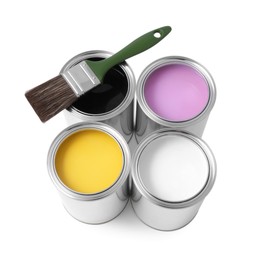 Cans of different paints with brush on white background, above view