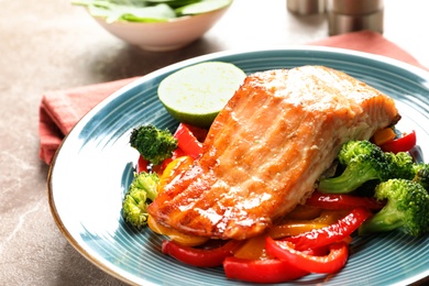 Tasty freshly cooked salmon and vegetables on plate, closeup