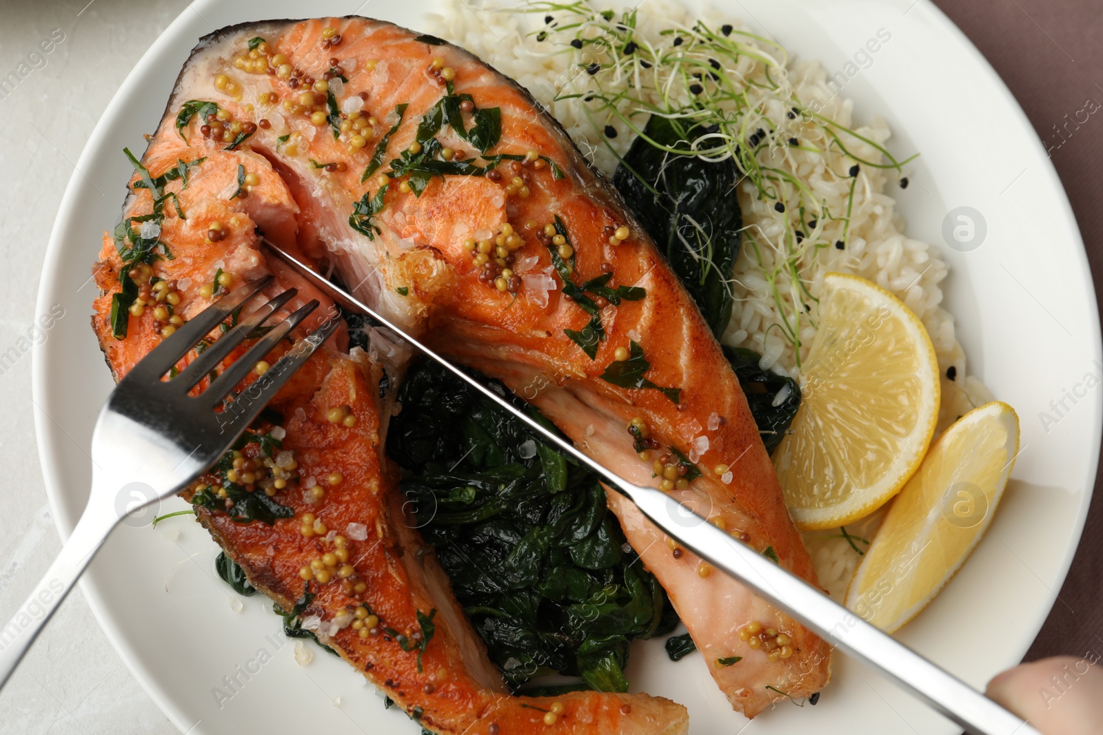 Photo of Tasty salmon with spinach on plate, closeup