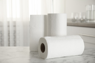 Rolls of paper towels on white marble table in kitchen, space for text