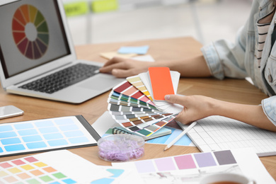 Photo of Professional interior designer with color palette at workplace in office, closeup