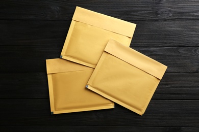 Kraft paper envelopes on black wooden background, flat lay