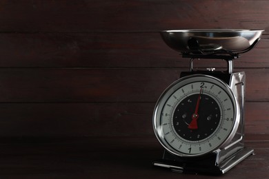 Photo of Retro mechanical kitchen scale on wooden table, space for text