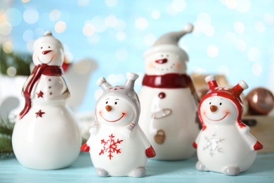 Four decorative snowmen on light blue table