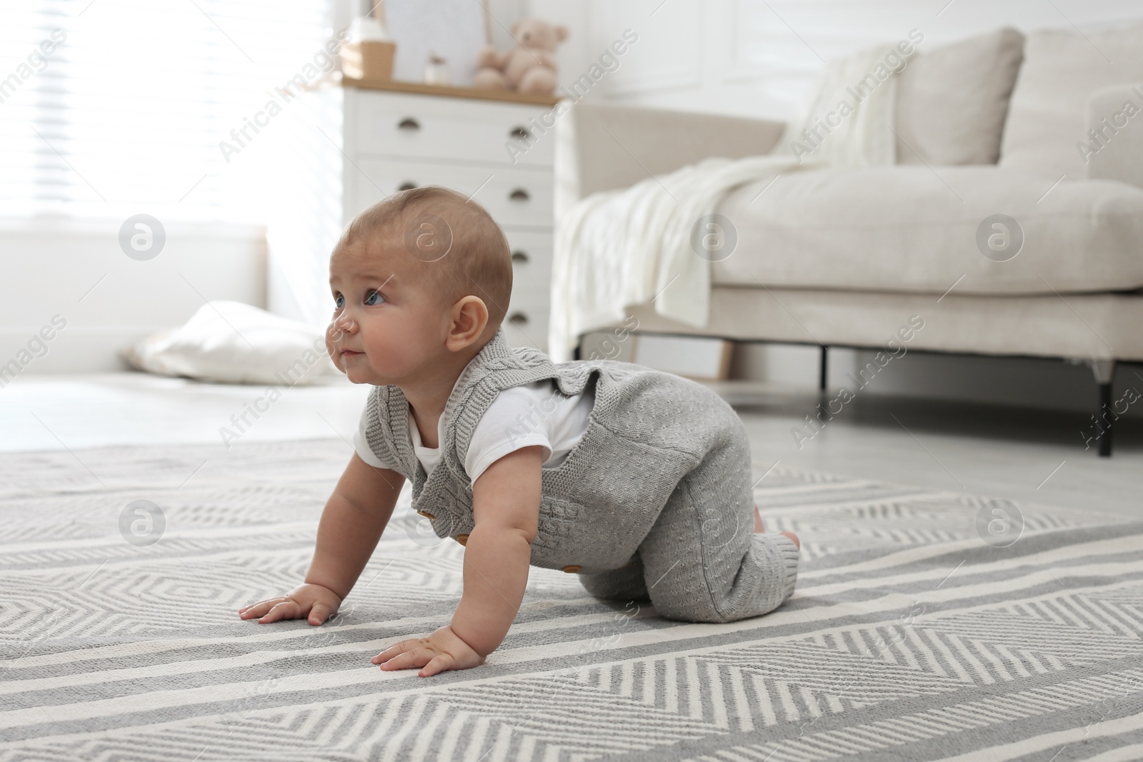 Photo of Cute baby crawling on floor at home