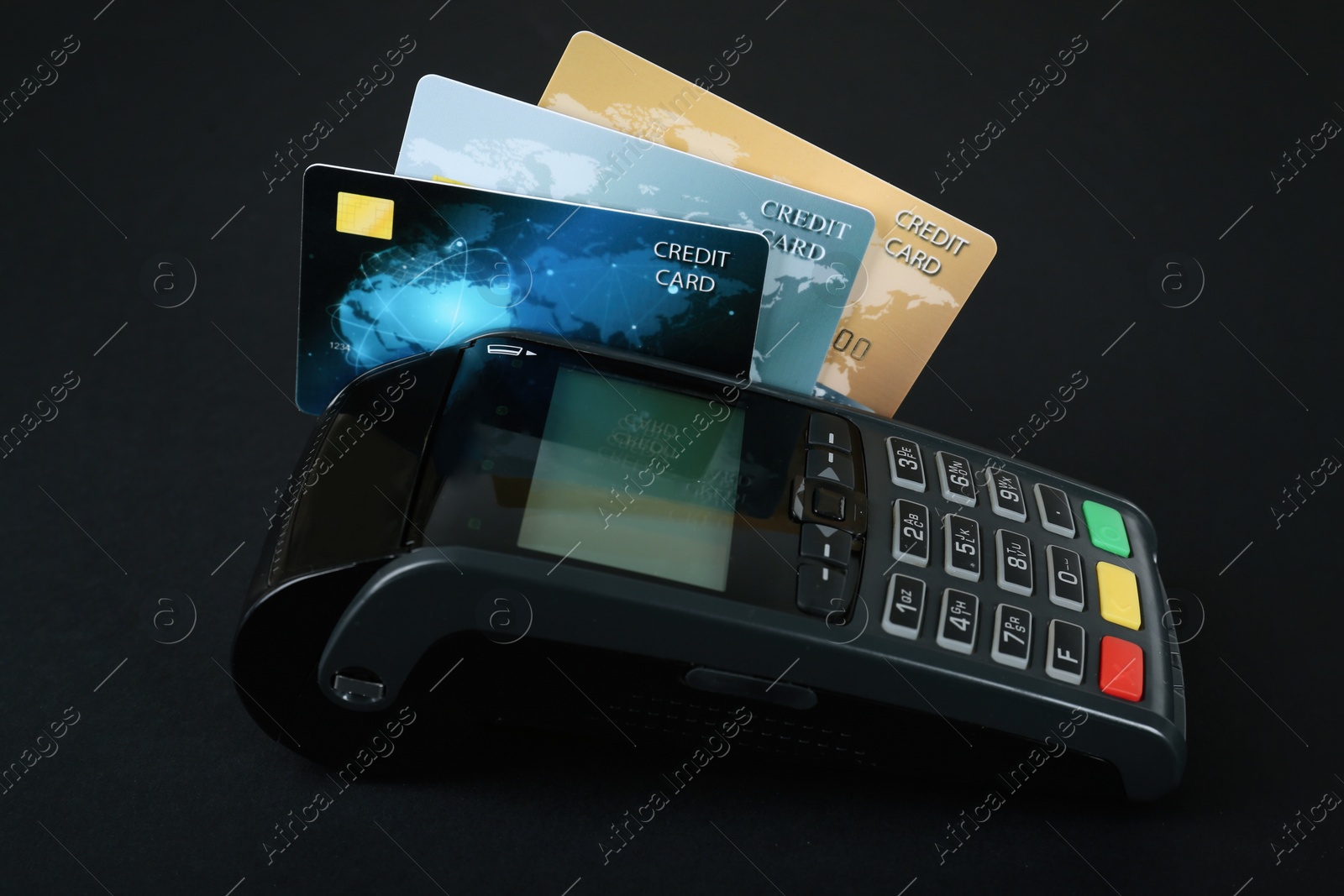 Photo of New modern payment terminal with credit cards on black background