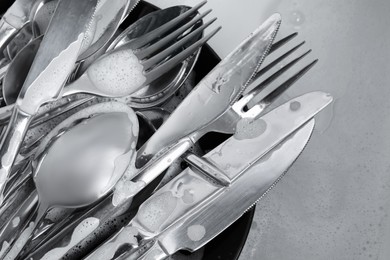 Photo of Washing silver spoons, forks and knives in kitchen sink, flat lay