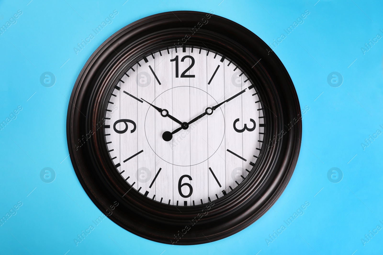 Photo of Stylish wall clock on turquoise background, top view