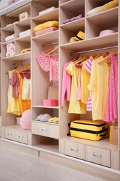 Stylish clothes, shoes and accessories in large wardrobe closet