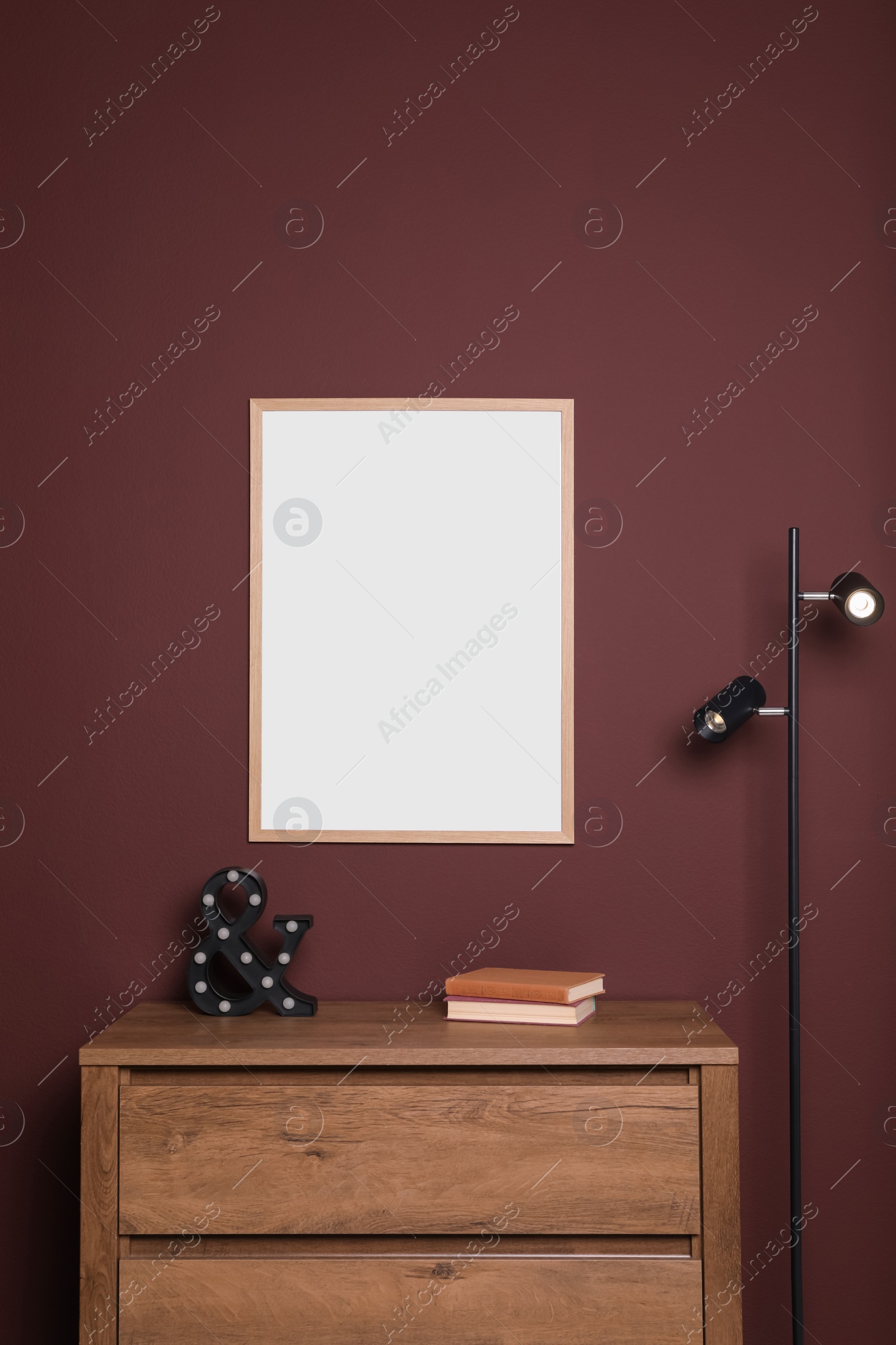 Photo of Blank frame hanging on dark wall indoors. Space for design