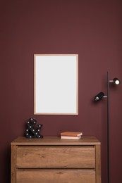 Blank frame hanging on dark wall indoors. Space for design