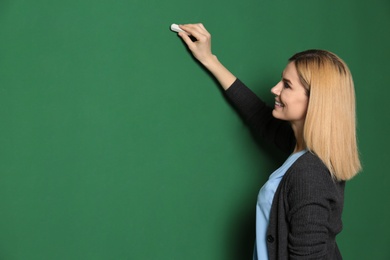 Beautiful teacher writing on chalkboard, space for text