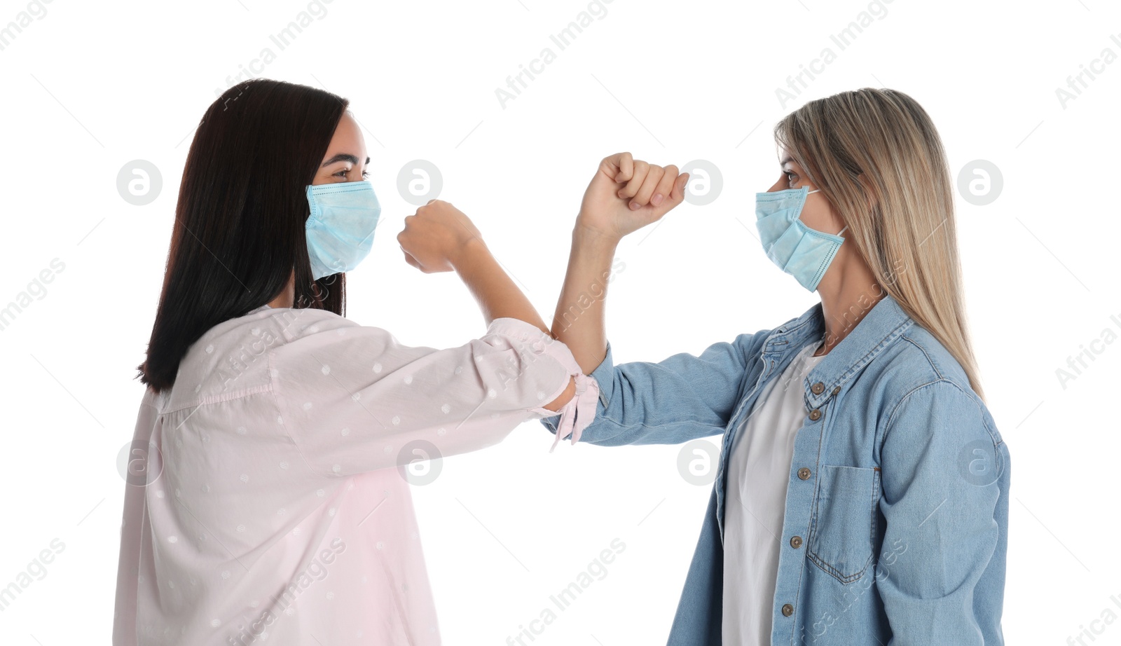 Photo of Women bumping elbows to say hello on white background. Keeping social distance during coronavirus pandemic