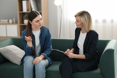 Psychotherapist working with patient on sofa in office