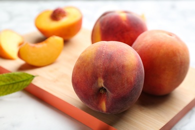 Photo of Fresh sweet peaches on wooden board, closeup