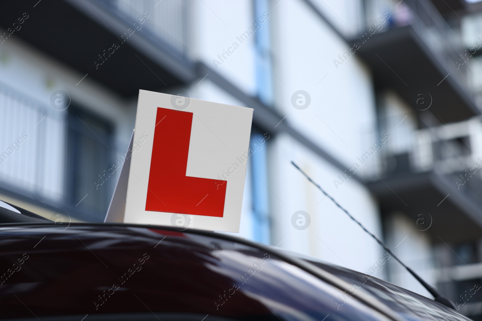 Photo of L-plate on car outdoors, space for text. Driving school