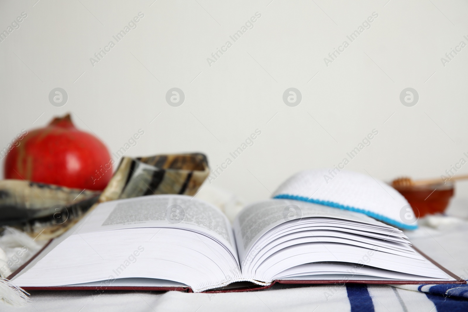 Photo of Open Torah, kippah and shofar on fabric, space for text. Rosh Hashanah celebration