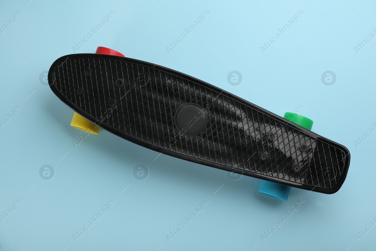 Photo of Black skateboard on turquoise background, top view