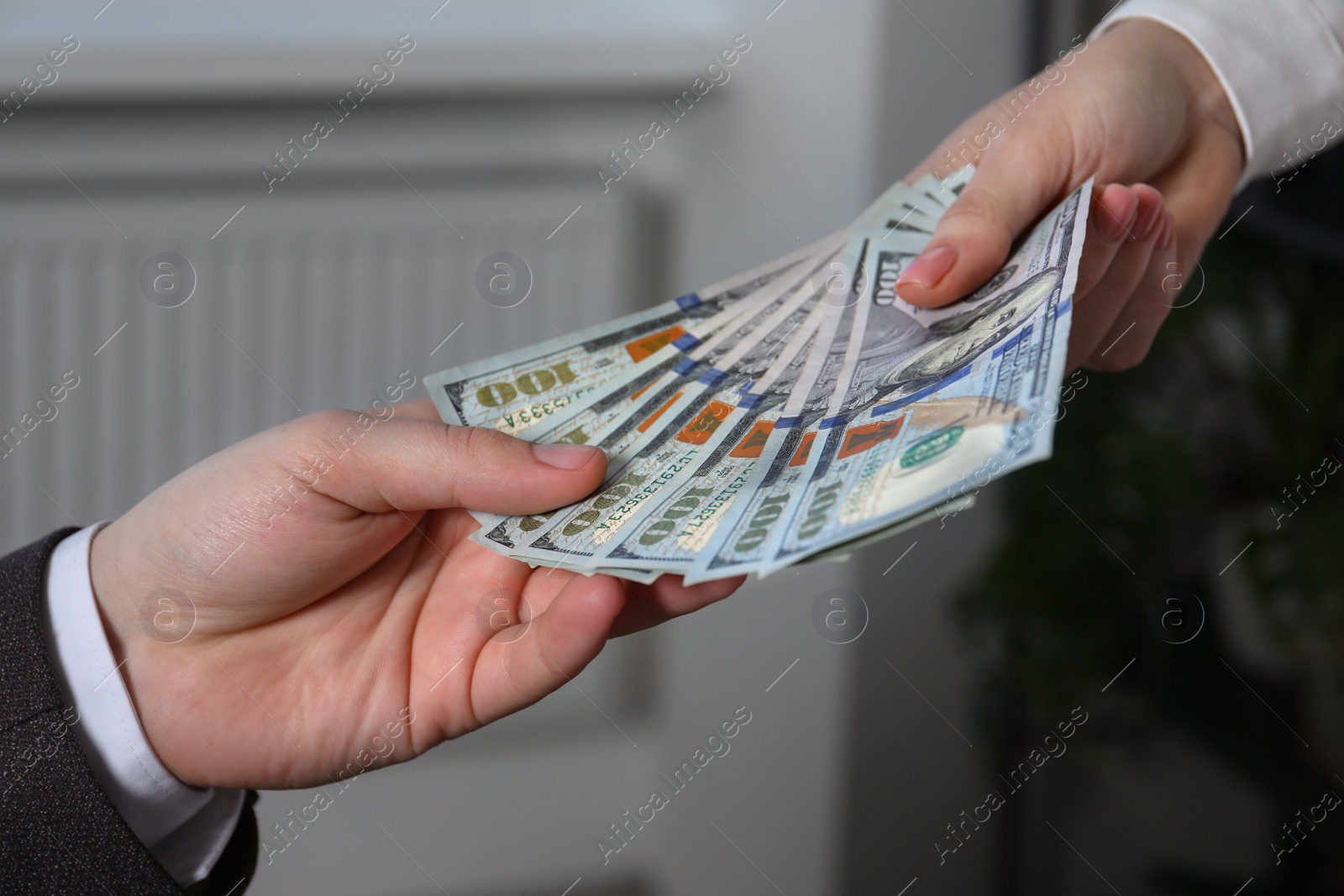 Photo of Woman giving money to man indoors, closeup. Currency exchange