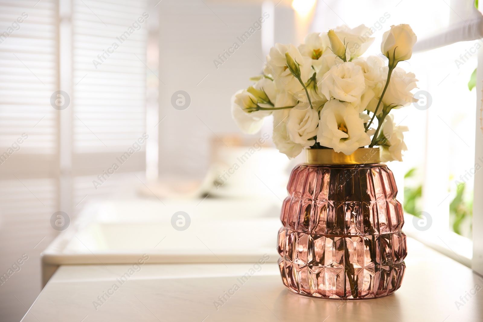 Photo of Bouquet of beautiful flowers on countertop in kitchen, space for text. Interior design