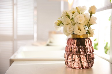 Photo of Bouquet of beautiful flowers on countertop in kitchen, space for text. Interior design