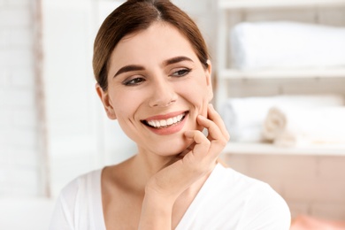 Young woman with beautiful smile indoors. Teeth whitening