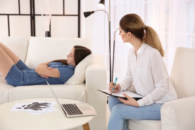 Female psychologist working with teenager girl in office