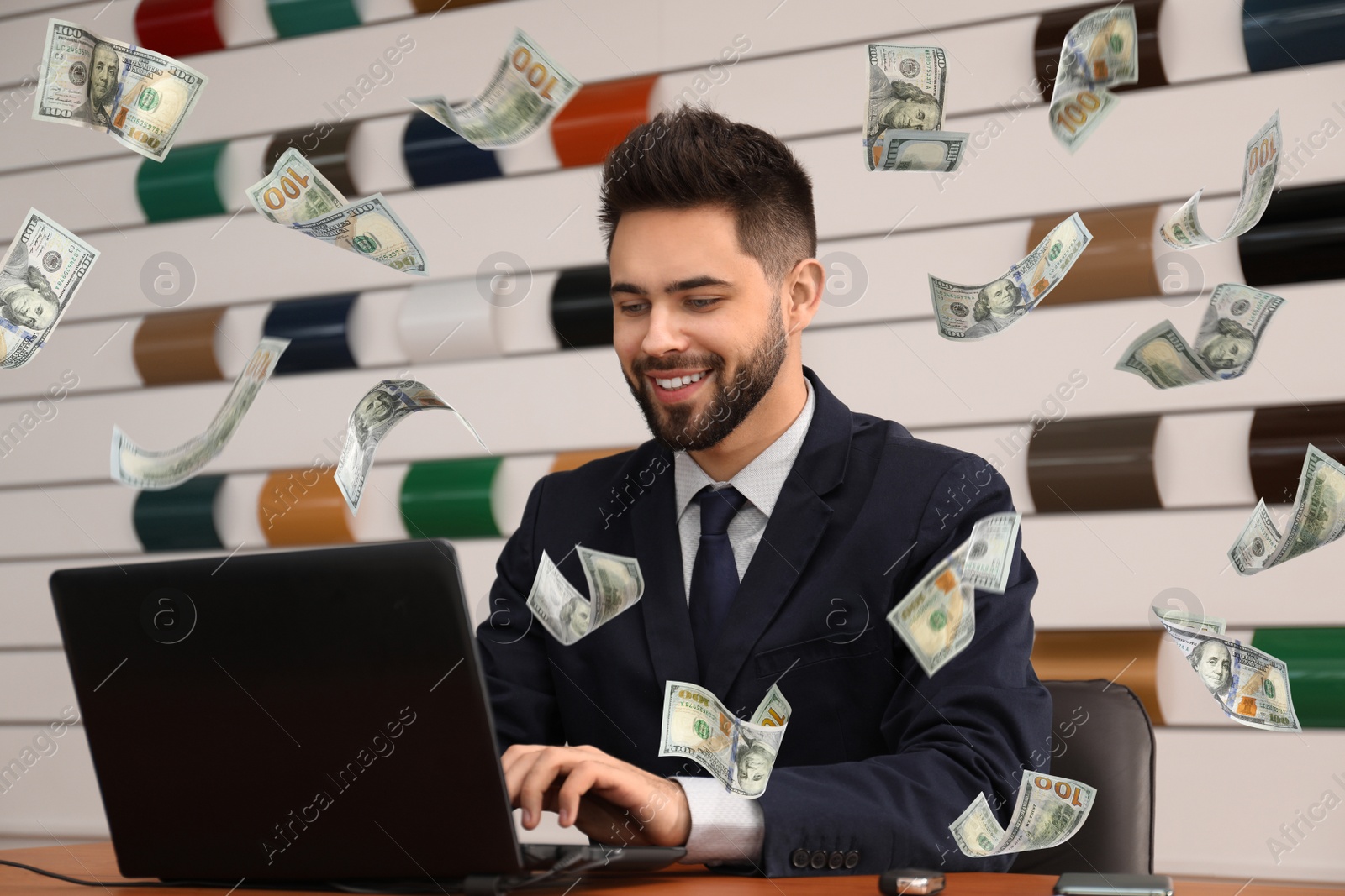 Image of Businessman with modern laptop and flying dollar banknotes at table in office. People make money online