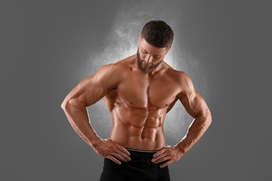 Photo of Young bodybuilder with muscular body on grey background
