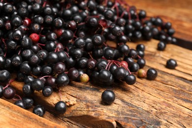 Photo of Black elderberries (Sambucus) on wooden table, closeup
